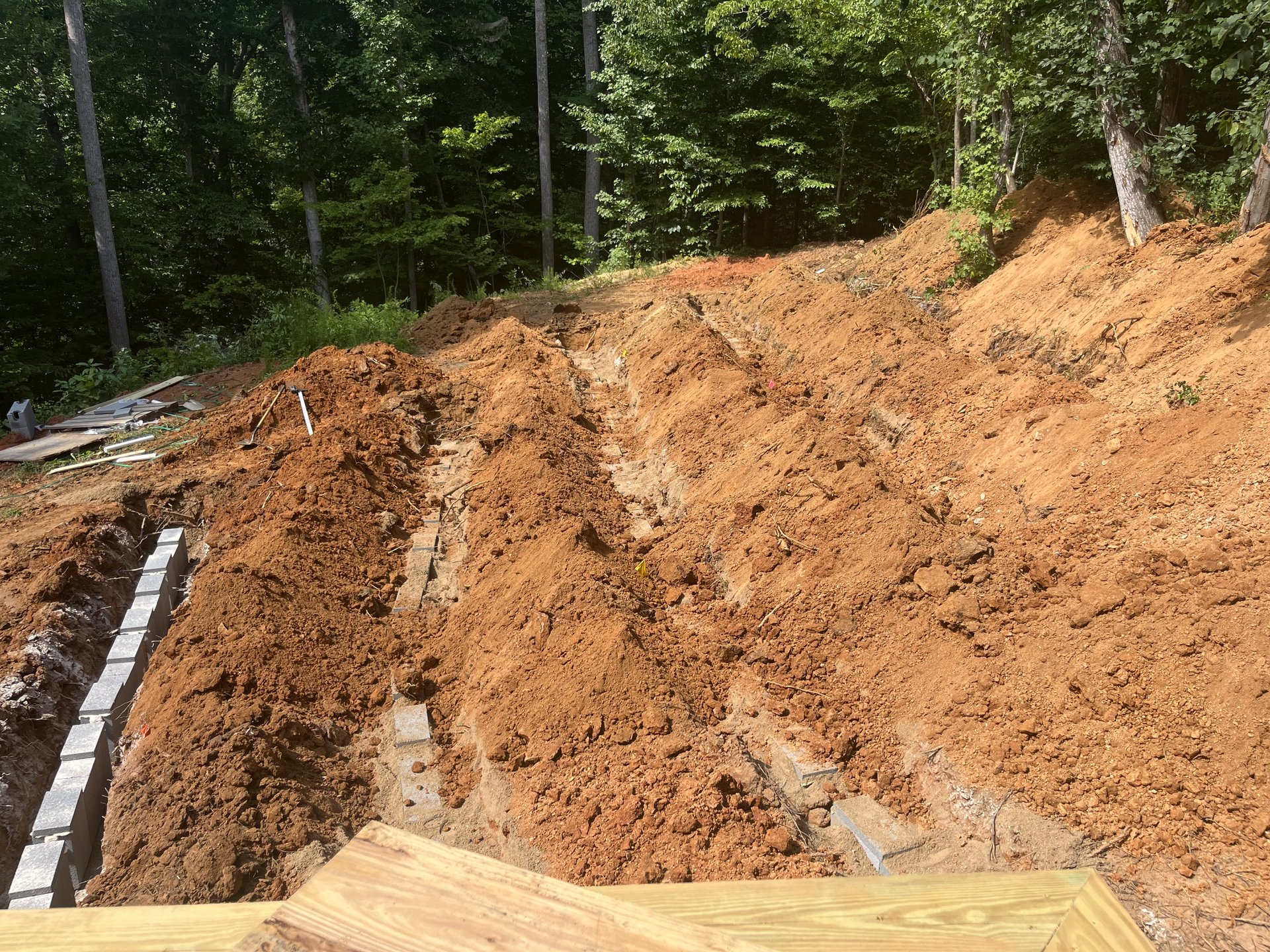 Semper Septic crew excavating a hillside septic drain field trench in Troutman, NC